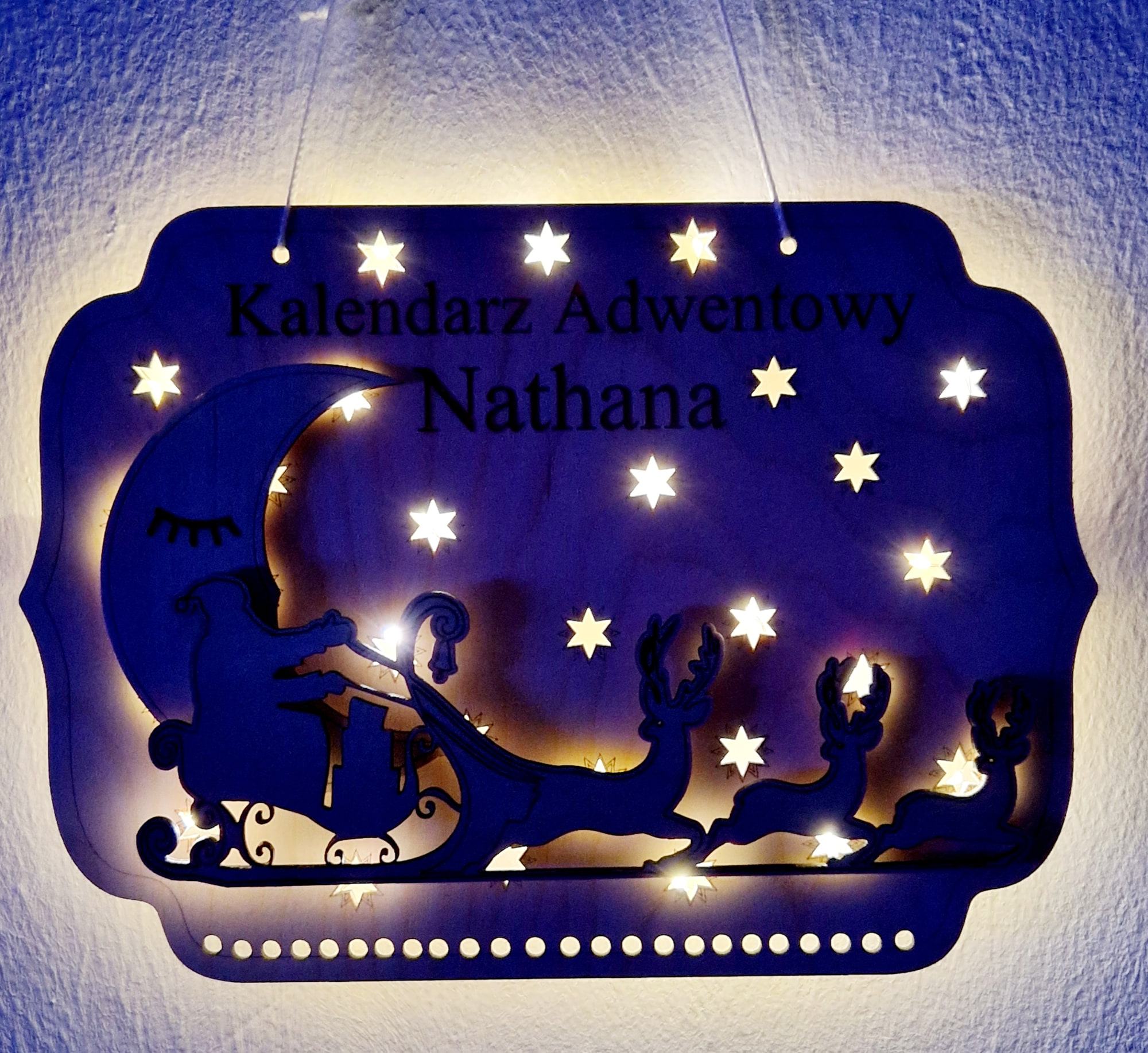 Houten adventskalender met naam, in blauw licht met gloeiende sterren