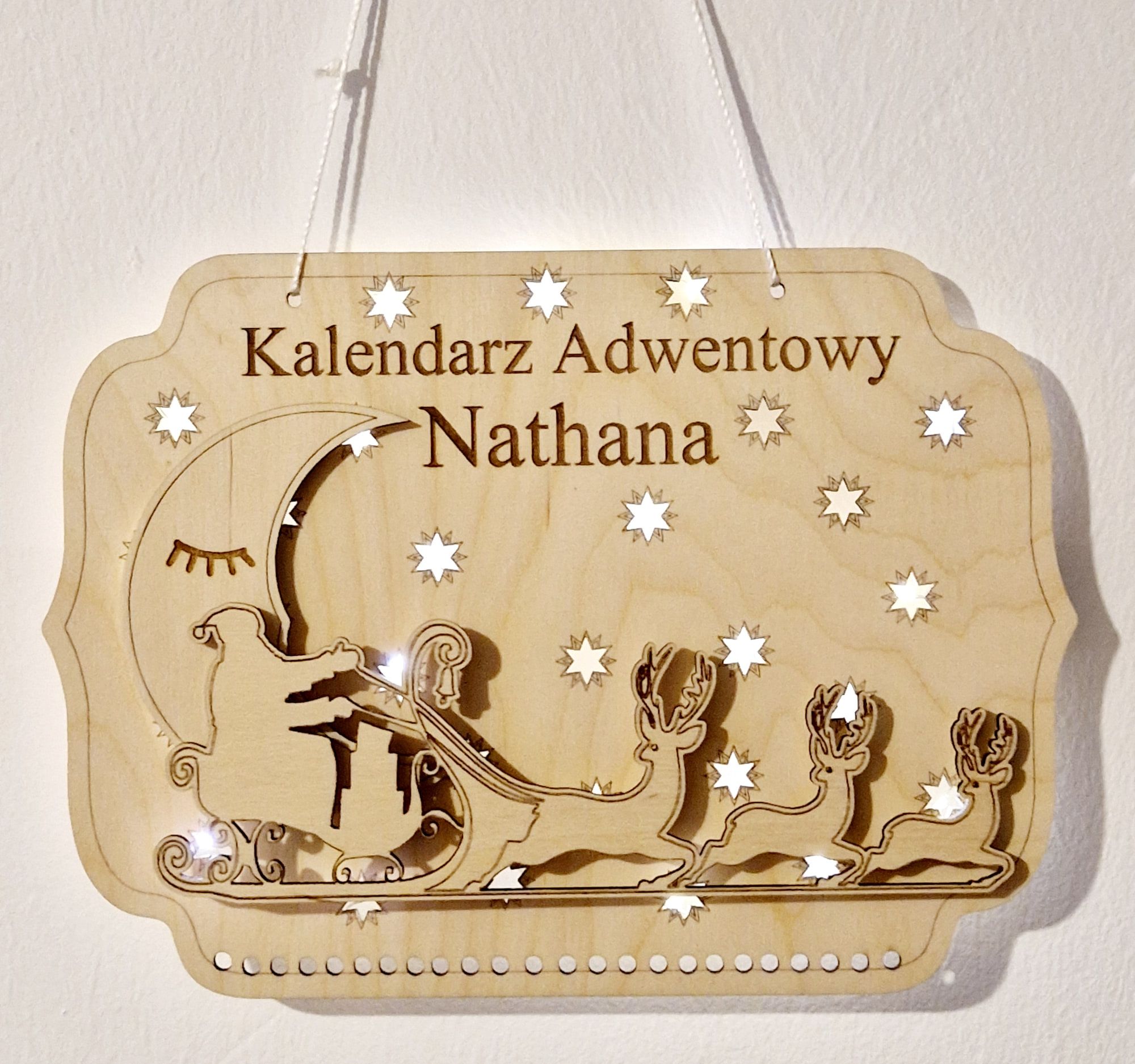 Adventskalender bij daglicht: gegraveerde naam en 24 haakjes