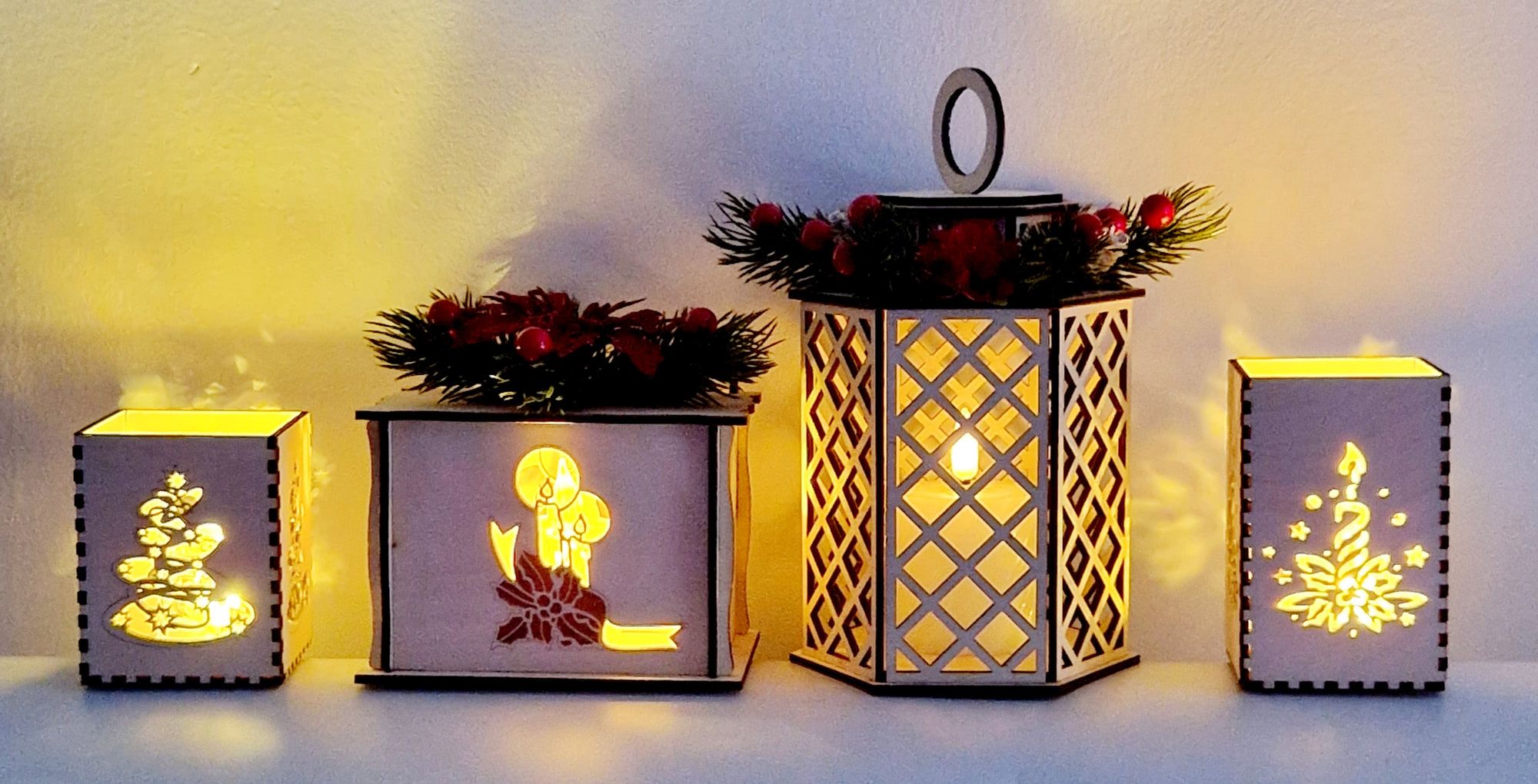 Vier lantaarns naast elkaar: kaars, kerstboom en ster