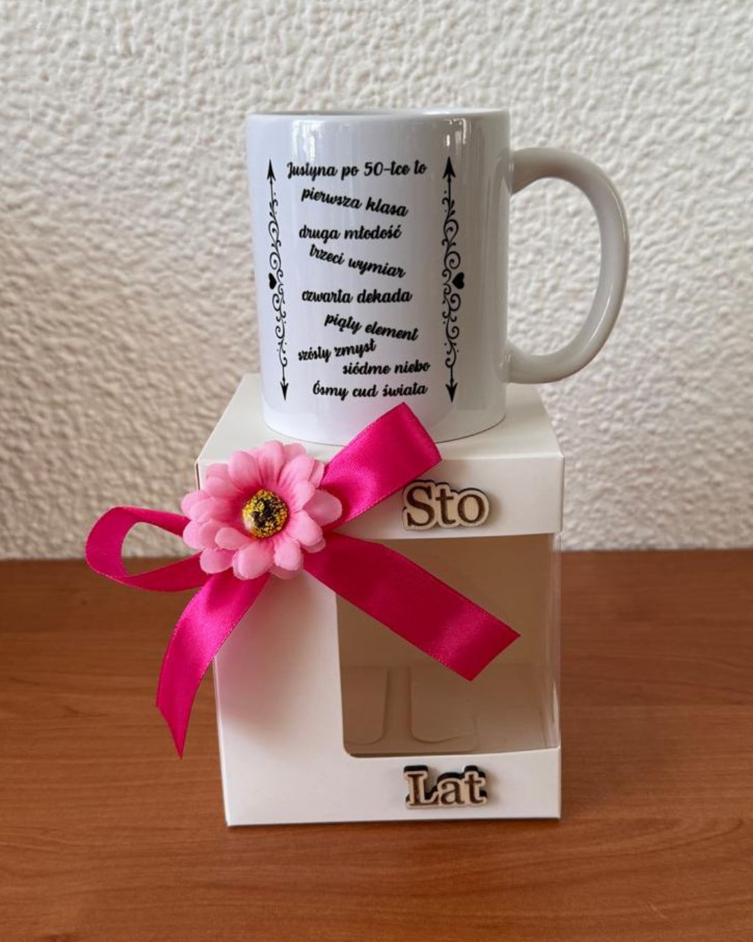 Gepersonaliseerde mok voor een 50e verjaardag, op een witte doos met roze strik