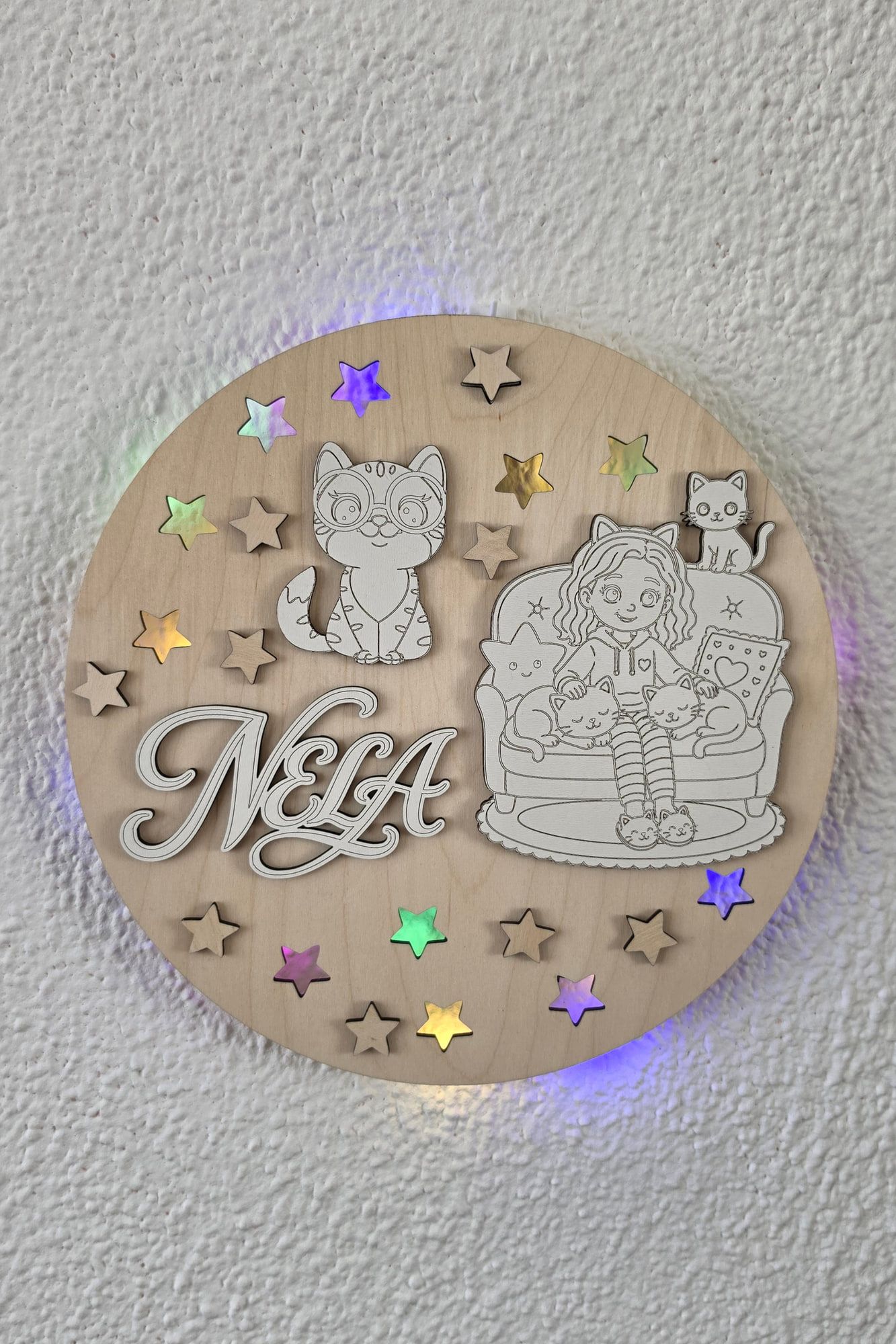 Rond houten naambord ‘Nela’ met poes, meisje en sterren, met kleurrijke ledverlichting