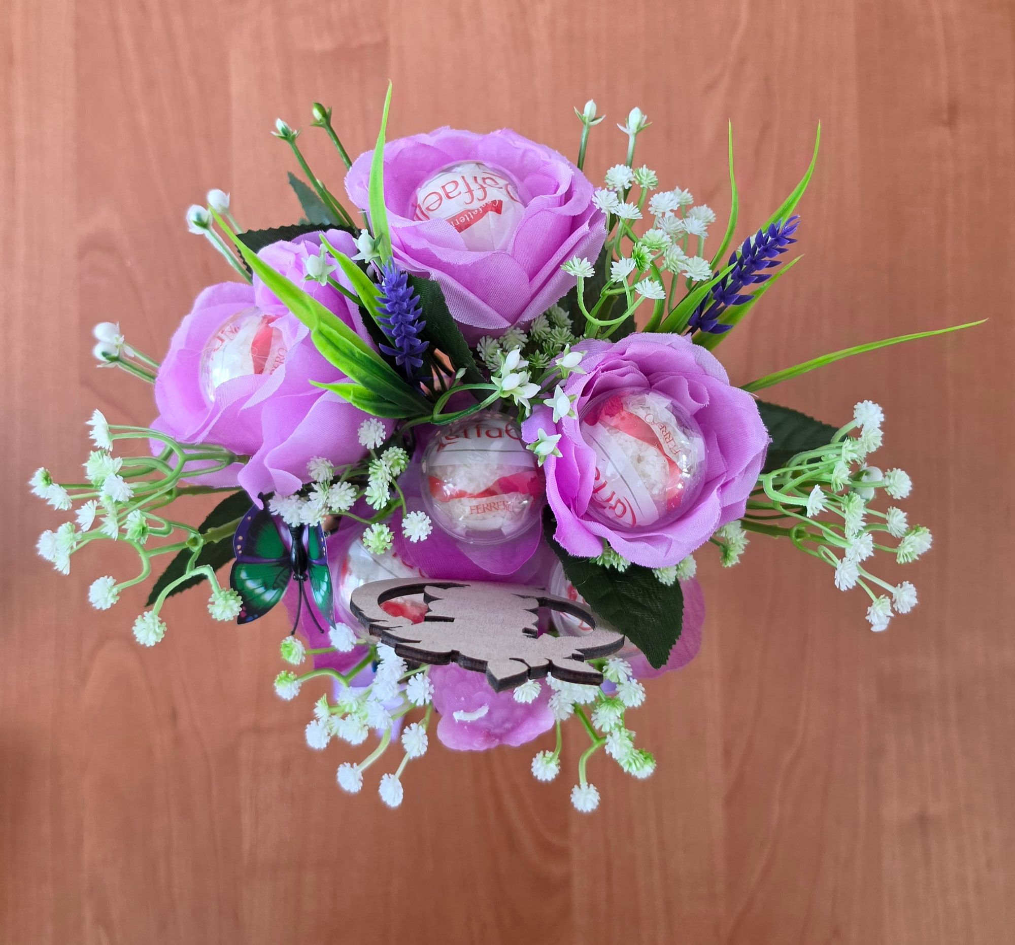 Het potloodboeket van bovenaf: paarse bloemen en snoep