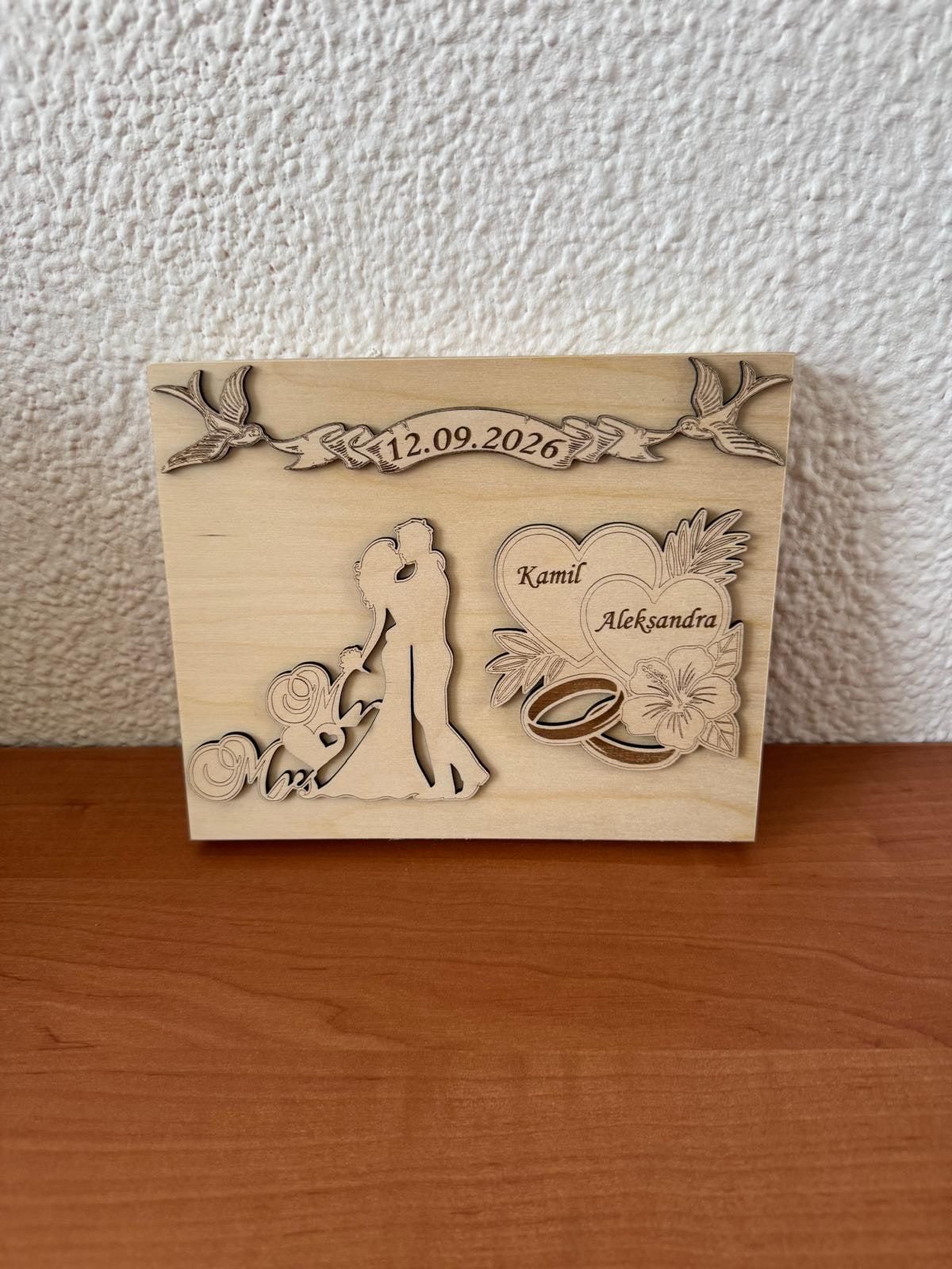 Houten trouwkaart met silhouet van het bruidspaar, hartjes en ringen