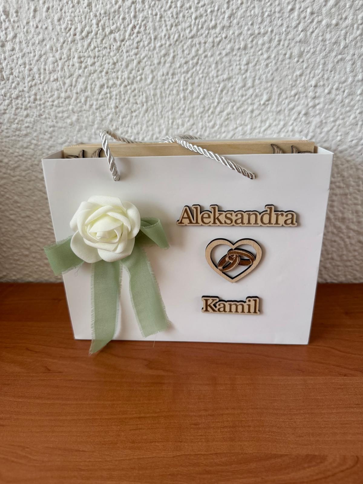 Witte cadeautas met houten namen, hart en roos voor een bruidspaar