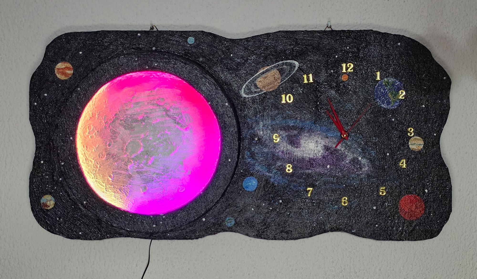 Wandklok met ruimtethema, verlichte maan en planeten